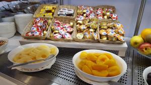 a counter with bowls of fruit and other snacks at Aurea Hotel in Tortoreto Lido