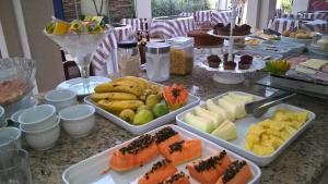 a table topped with trays of different types of food at Primavera Palace Hotel in Nova Andradina