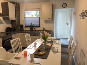 eine Küche mit einem Tisch und einer Blumenvase darauf in der Unterkunft Ferienhaus Kluntje in Emden