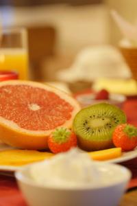 een bord met grapefruit en aardbeien op een tafel bij Hotel Refrather Hof in Bergisch Gladbach