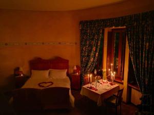 een slaapkamer met een bed en een tafel met kaarsen bij Al Borducan Romantic Hotel - Adults Only in Varese
