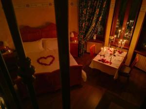 una camera da letto con un letto e un tavolo con un cuore sopra di Al Borducan Romantic Hotel - Adults Only a Varese
