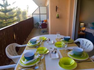 デニアにあるDenia playa de Las Marinas, 4 personnesのテーブル(黄色・青色の皿、グラス付)