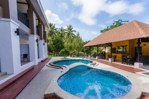 una piscina en medio de una casa en The Retreat Khaolak Resort - SHA Extra Plus en Khao Lak