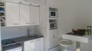 ヴィルヌーヴ・ルベにあるRésidence Cap Azur Appartement 228の白いキッチン(白いキャビネット、シンク付)