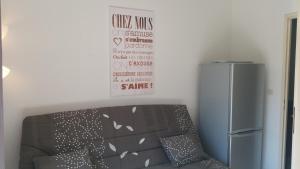 ヴィルヌーヴ・ルベにあるRésidence Cap Azur Appartement 228の冷蔵庫の横にサイン付きのソファ