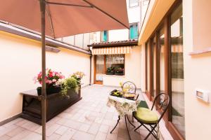a patio with a table and chairs and an umbrella at Arena Dreams Apartment in Verona