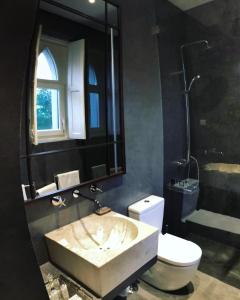 a bathroom with a sink and a toilet and a shower at A Capela - A Essência de Sintra in Sintra