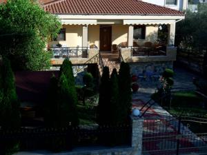uma casa com uma cerca em frente a um quintal em Lioharis Villa em Skala Rachoniou