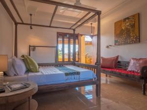 a bedroom with a bed and a couch at Maruti Lane Villa in Ubud