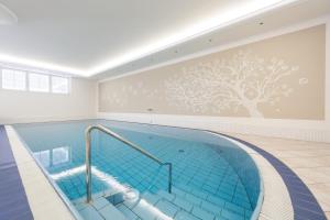 uma piscina com um mural de uma árvore em Park Hotel Bellevue em Dobbiaco