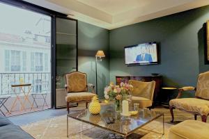 ニースにあるZe Perfect Place - Élégant appartement avec terrasse - Promenade des Artsのリビングルーム(ソファ、椅子、テレビ付)