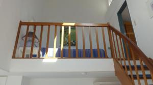 a staircase with a wooden rail and a mirror at Ferienwohnung Meisennest in Cuxhaven
