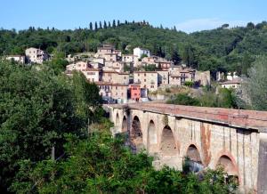 un vecchio ponte di pietra con una città sullo sfondo di Locanda del Borgo a Todi