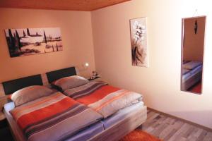 1 dormitorio con 1 cama y algunas fotos en la pared en Ferienwohnung Irene, en Zwiesel