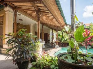 a house with a pool and plants in front of it at Maruti Lane Villa in Ubud