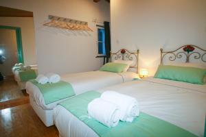 two beds in a hotel room with towels on them at Casa dos Batalim in Monchique