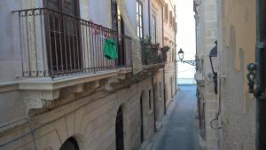 an alley with a green towel hanging on a balcony at A 100 passi da Calarossa in Syracuse