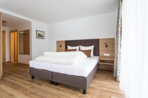 a bedroom with a large bed with white sheets at Das Landerer in Ladis