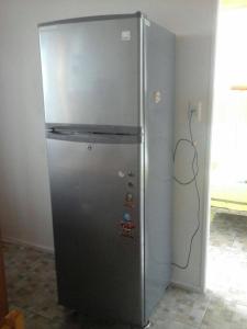a stainless steel refrigerator in a kitchen next to a wall at Cabanas bahia inglesa in Bahia Inglesa