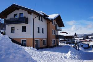 un edificio cubierto de nieve con nieve alrededor en Appartements Real en Schladming