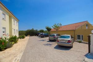 a parking lot with cars parked next to a building at Apartments Gornje Starine in Tribunj