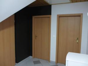 dwa drzwi w pokoju z czarną ścianą w obiekcie Mylak w Korbielowie