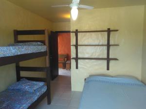 a room with two bunk beds and a hallway at Condominio Sargento Laranja in Garopaba