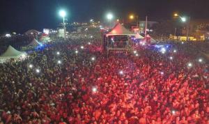 Pousada Portal da Ilha في إيتاوكا: زحمة كبيرة من الناس بلبس احمر بالليل