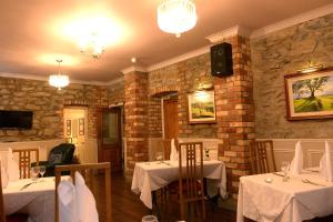 un restaurante con 2 mesas con mantel blanco en Ardgort Country House, en Castlederg