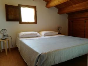a bedroom with a large bed with a window at Casetta Rosina in Scopello