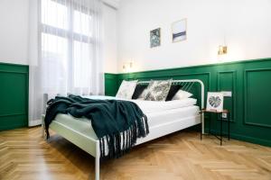 una camera da letto verde e bianca con un letto con una parete verde di P&J Luxury Apartments a Cracovia