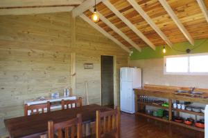 a kitchen with a table and a refrigerator at Playa Grande Frente al Mar in San Clemente del Tuyú