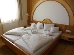 a bed with a teddy bear sitting on top of it at Hotel Neuwirt in Ramsau am Dachstein