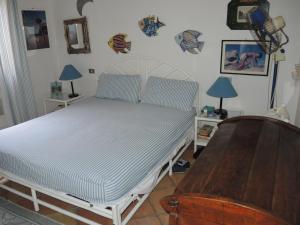 un letto in una stanza con due tavoli e due lampade di Sea View Eden a Porto Cervo
