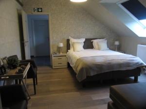 sypialnia z dużym łóżkiem i pokój ze stołem w obiekcie au-magasin w mieście Vielsalm