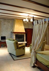 a living room with a chair and a fireplace at La Azacaya in Baeza