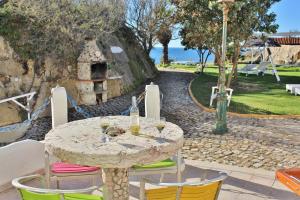 a table with chairs and a table with wine glasses at Villa Ana Margarida Beach in Ericeira