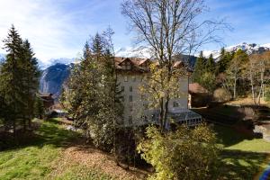 a building on a hill with mountains in the background at Apartment Belvedere in Wengen