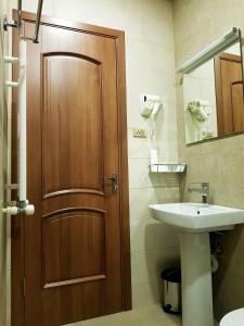 uma casa de banho com uma porta de madeira e um lavatório em Cozy Hotel Kazbegi em Stepantsminda