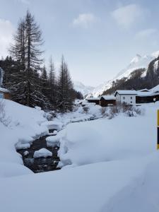 ein schneebedeckter Bach neben einem Berg in der Unterkunft Haus am Brunnen in Samnaun