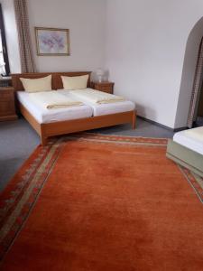 a bedroom with a bed and a rug at Gasthof zum Rassen in Garmisch-Partenkirchen