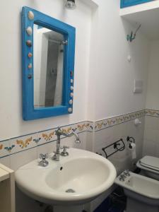 y baño con lavabo y espejo azul. en R9, en Vulcano