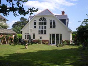 a dog standing in the yard of a house at Heatherdene House in Wimborne Minster