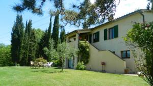a house with a yard with chairs and trees at Le Rogheta in Campiglia dʼOrcia