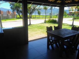 a table and chairs in a porch with a view of a street at Condominio Sargento Laranja in Garopaba