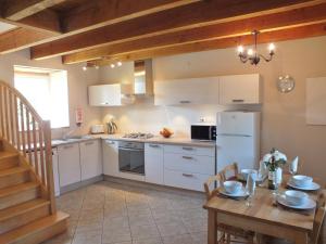 a kitchen with a table and a white refrigerator at Gites De Lenvos in Pontivy