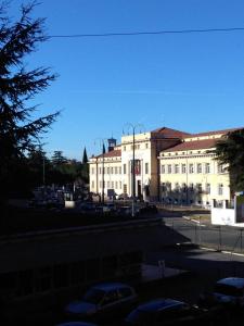 ein großes weißes Gebäude mit Autos auf einem Parkplatz in der Unterkunft B&B Mameli 41 in Verona