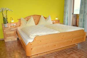 バルビアーノにあるHaus Hoferの黄色い壁のベッドルームの木製ベッド1台