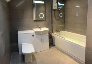 een badkamer met een wastafel, een toilet en een ligbad bij Apartment 5, Cornerhouse Apartments in Llandudno +19 foto's